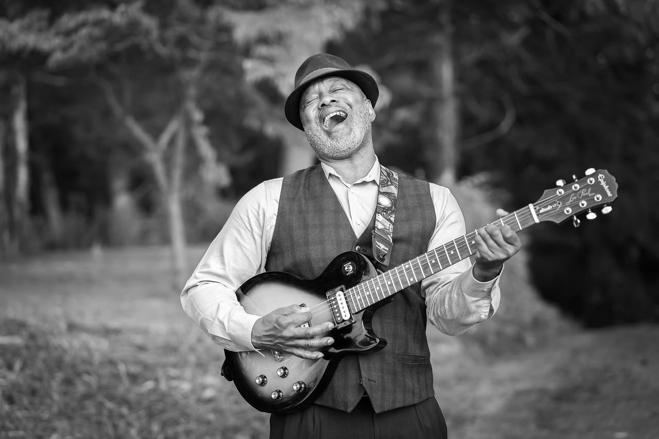 man singing with a guitar in hand