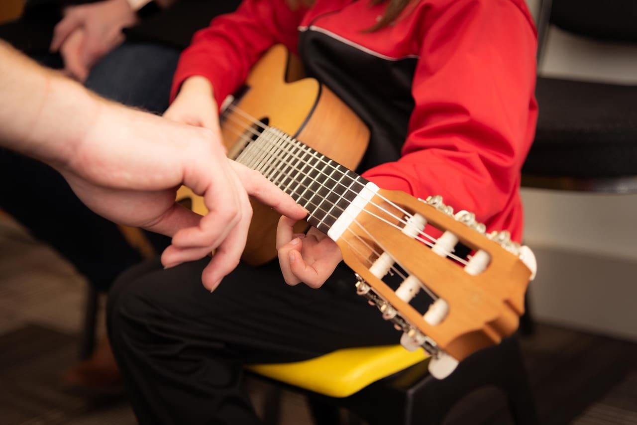 Child learning to play the guitar