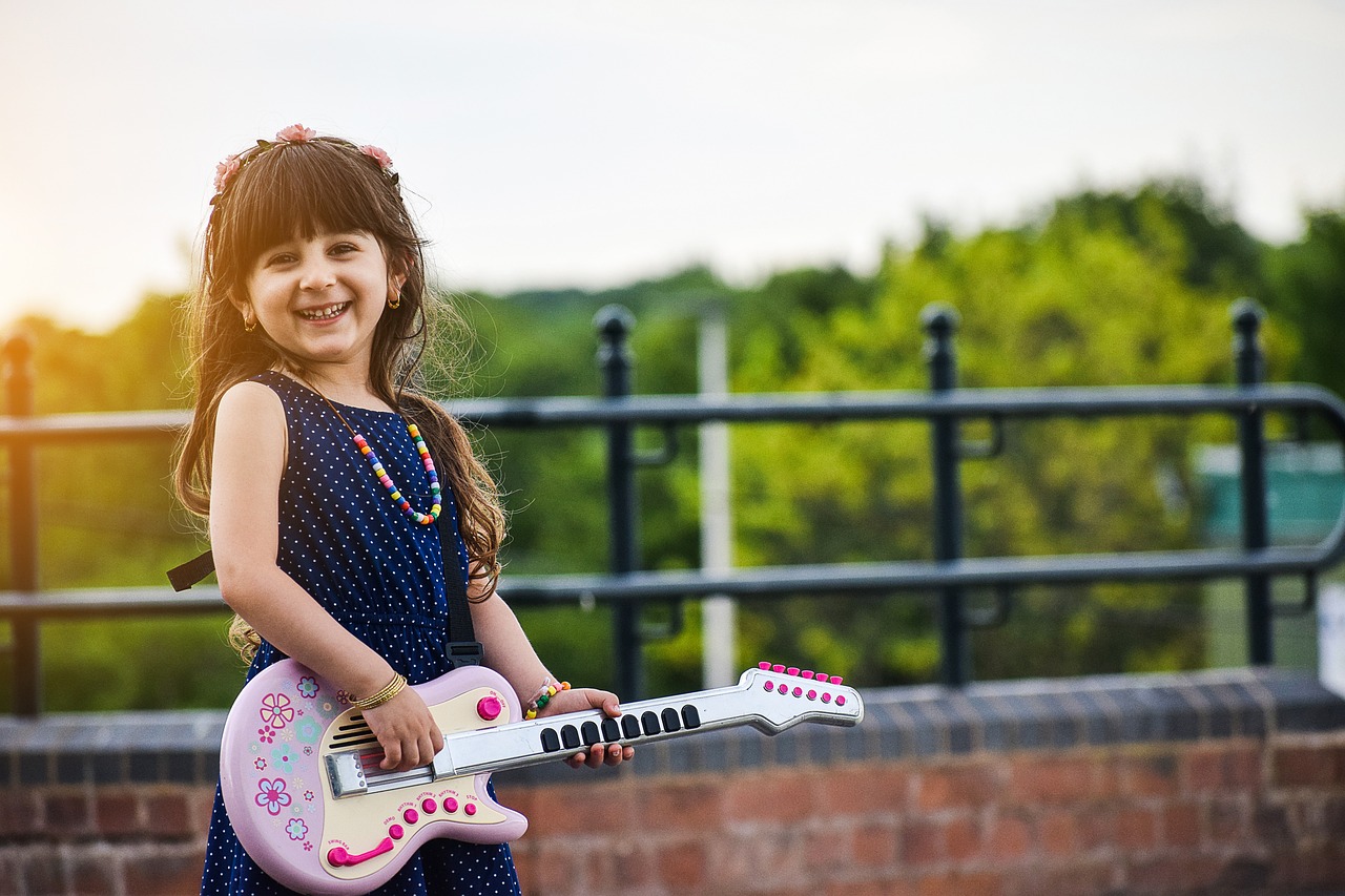 Little girl learning to play guitar