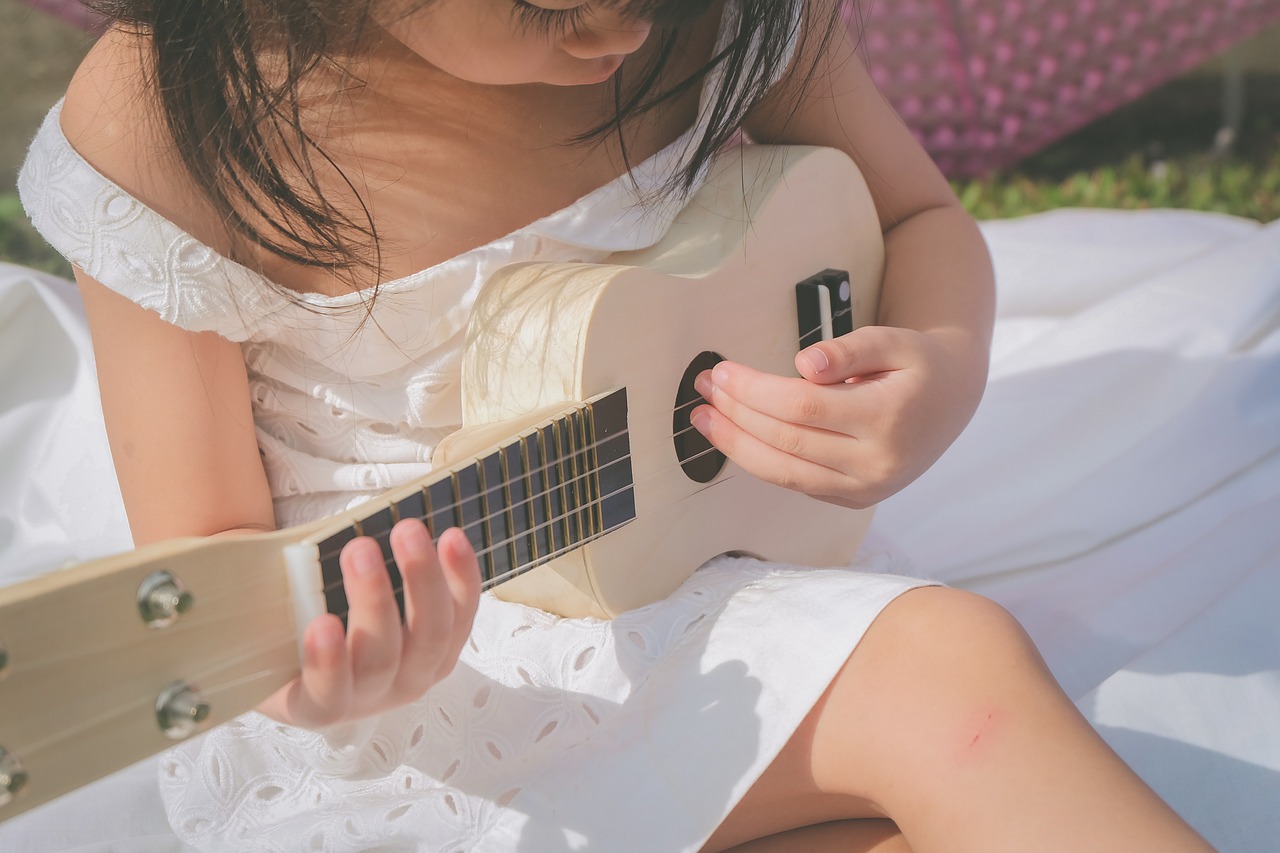 Child playing a white guitar